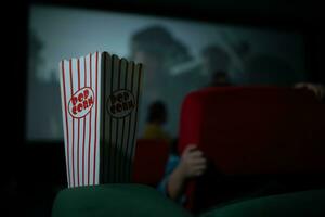 bioscoop concept. mensen aan het kijken film Bij bioscoop aan het eten popcorn foto