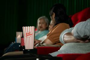bioscoop concept. mensen aan het kijken film Bij bioscoop drinken water en aan het eten popcorn foto
