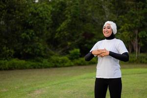 prettige vrouw in hijab en sportkleding die yoga doet en zich uitstrekt. foto