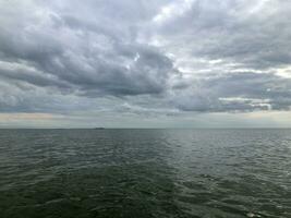 dramatisch zeegezicht laag donker wolken over- de zee foto