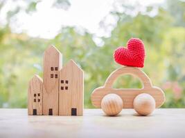 miniatuur huis, rood hart en houten speelgoed- auto. concept van familie foto