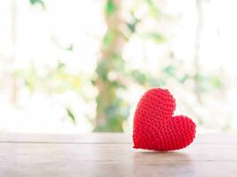 dichtbij omhoog van rood hart handgemaakt Aan houten tafel voor Valentijnsdag dag of bruiloft achtergrond foto