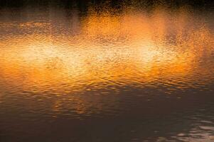 wazig achtergrond van oppervlakte water in de zonsondergang tijd foto