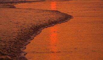 water en zand Bij de strand in zonsondergang tijd foto