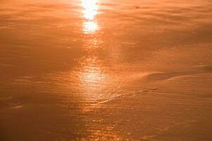 water en zand Bij de strand in zonsondergang tijd foto