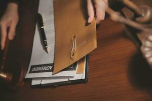 zaken en advocaten bespreken contractpapieren met koperen schaal op bureau in kantoor. wet, juridische diensten, advies, rechtvaardigheid en wet concept foto met film grain effect