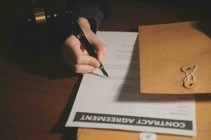 zaken en advocaten bespreken contractpapieren met koperen schaal op bureau in kantoor. wet, juridische diensten, advies, rechtvaardigheid en wet concept foto met film grain effect