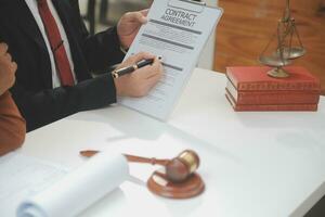 zaken en advocaten bespreken contractpapieren met koperen schaal op bureau in kantoor. wet, juridische diensten, advies, rechtvaardigheid en wet concept foto met film grain effect