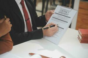 zaken en advocaten bespreken contractpapieren met koperen schaal op bureau in kantoor. wet, juridische diensten, advies, rechtvaardigheid en wet concept foto met film grain effect