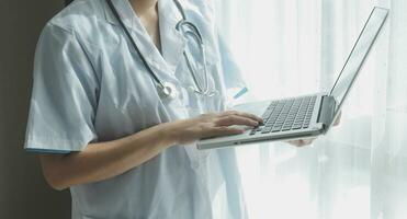 dokter werken met laptop computer in medisch werkruimte kantoor. dokter werken Aan laptop computer in modern klinieken kantoor. zoeken medisch informatie. banier kopiëren ruimte foto