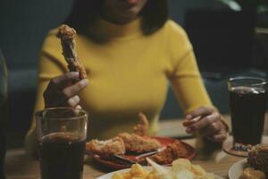 dik vrouw beet stuk van pizza, overgewicht vrouw is aan het eten snel voedsel, aziatisch meisje is hongerig foto