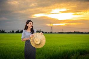 Aziatische vrouw in landelijke scène bij zonsondergang foto