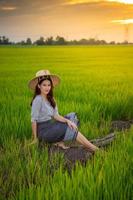 Aziatische vrouw in landelijke scène bij zonsondergang foto