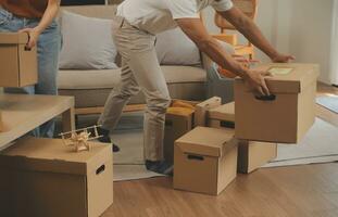 mooi jong paar in liefde hebben pret uitpakken dingen van karton dozen terwijl in beweging in samen in hun nieuw appartement foto