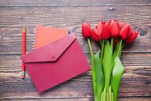 envelop en rode tulp op tafel foto