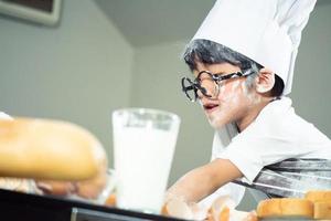 aziatische jongen draagt een bril plaag vader aan het koken foto