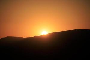 kleurrijke zonsondergang over een woestijnberglandschap foto