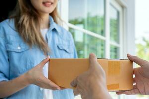 gelukkig glimlachen vrouw ontvangt dozen pakket van koerier in voorkant huis. levering Mens sturen leveren uitdrukken. online winkelen, papier containers, afhalen, postbode, levering onderhoud, pakketjes foto