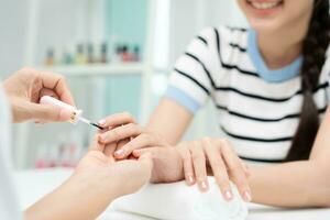 vrouw te ontvangen zorg onderhoud door professioneel schoonheidsspecialist manicure Bij spa centrum. nagel schoonheid salon gebruik nagel het dossier voor beglazing behandeling. manicure maken nagel klant naar mooi. lichaam zorg spa behandeling foto