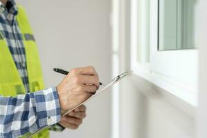 inspecteur of ingenieur is inspecteren bouw en kwaliteit zekerheid nieuw huis gebruik makend van een controlelijst. ingenieurs of architecten of contactor werk naar bouwen de huis voordat overhandigen het over- naar de huiseigenaar foto