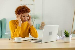 Afrikaanse vrouw aanraken tempels ervaren spanning. meisje Bij huis kantoor moe van werken gevoel hoofdpijn ziek wrijven tempels voorhoofd. lang laptop gebruik computer visie syndroom. kantoor syndroom. foto