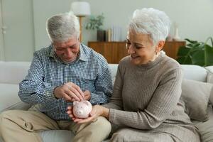 besparing geld investering voor toekomst. senior volwassen volwassen paar Holding varkentje bank zetten geld munt. oud Mens vrouw tellen besparing geld planning pensioen begroting. besparing investering bank concept. foto