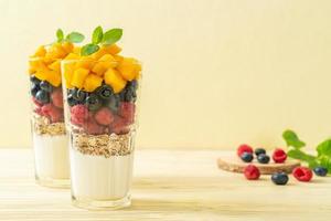 zelfgemaakte mango, framboos en bosbes met yoghurt en muesli - gezonde voedingsstijl foto