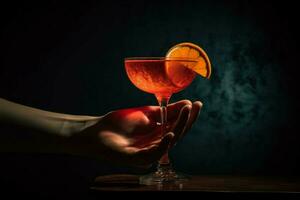 een hand- Holding een rood cocktail glas met een plak foto