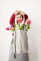 vrouw met grijze polka dot stoffen tas met kleurrijke tulpen foto