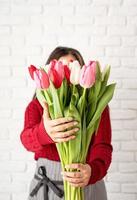 vrouwelijke bloemist die een boeket verse kleurrijke tulpen maakt foto
