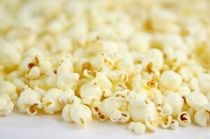 vier kleurrijk kommen van popcorn Aan een wit oppervlakte foto