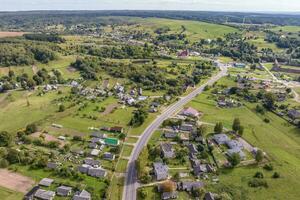 panoramisch antenne visie van eco dorp met houten huizen, grind weg, tuinen en boomgaarden foto