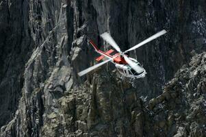 een helikopter is vliegend over- een rotsachtig berg foto