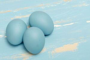 eieren symboliseert de Pasen vakantie in blauw kleur Aan een achtergrond van oud hout foto