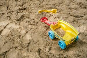vlak leggen van een strand speelgoed- uitrusting verspreiding uit Aan de zanderig oppervlakte van een buitenshuis speelplaats. foto