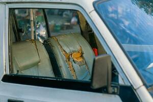 de auto stoel bekleding is beschadigd, lek, en gescheurd in de oud auto. foto