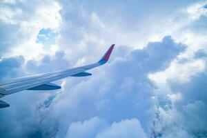 Doorzichtig blauw lucht met pluizig sier- cumulus wolken, panoramisch visie van een vliegtuig, vleugel detailopname. droomachtige wolkenlandschap. reis, toerisme, vakanties, turbulentie. foto