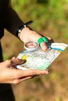 vrouw Holding een kaart en de kompas gedurende oriëntatielopen wedstrijden. foto