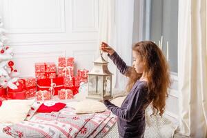 wit lang haren meisje siert een kamer met Kerstmis speelgoed. foto