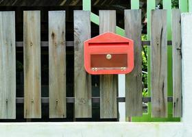 brievenbus rode kleur op het houten hek foto