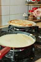 Koken crêpe suzette pannekoeken in frituren pan Aan gas- fornuis. vetten pannekoeken met boter foto