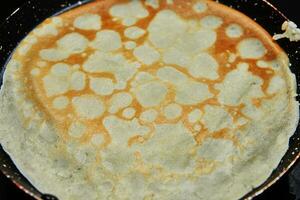 Koken crêpe suzette pannekoeken in frituren pan Aan gas- fornuis foto