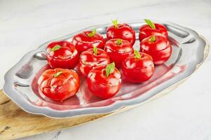 gevuld tomaten met basilicum blad Aan bord Aan licht achtergrond foto