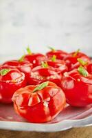 gevuld tomaten met basilicum blad Aan bord Aan licht achtergrond foto