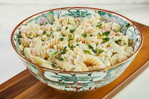 fusilli salade met garnaal en groen uien in gekleurde kom foto