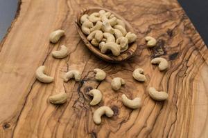 een stapel cashewnoten op olijfhout foto