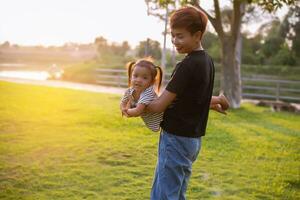 een silhouet van een gelukkig jong moeder harmonisch familie buitenshuis. lachend en spelen in de zomer Aan de zonsondergang achtergrond.sstkhome foto