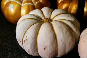 mooi geschilderd pompoenen van wit en goud kleur Aan halloween foto