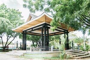 een Chinese stijl kiosk omringd door bomen, een park met een Japanse stijl kiosk, concept van een klein Japans tempel foto