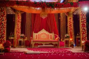een Indisch bruiloft stadium versierd met rood en goud. ai-gegenereerd foto